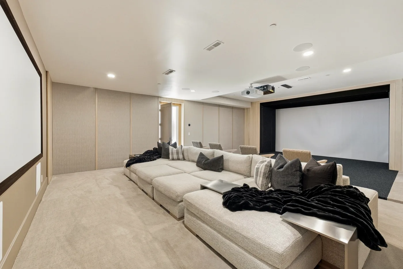 A home theater with a large screen and rows of cushioned seating.