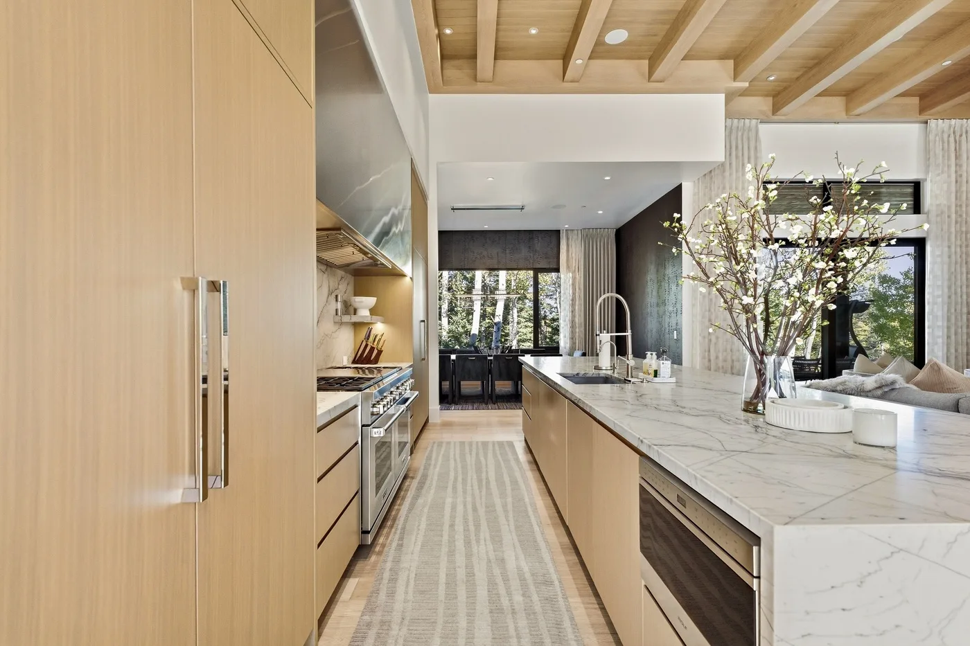 A bright kitchen with a long island and large windows.