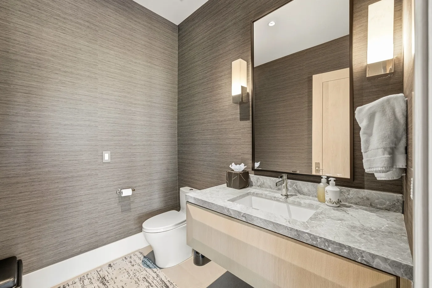 A bathroom with a vanity, sink, and toilet.