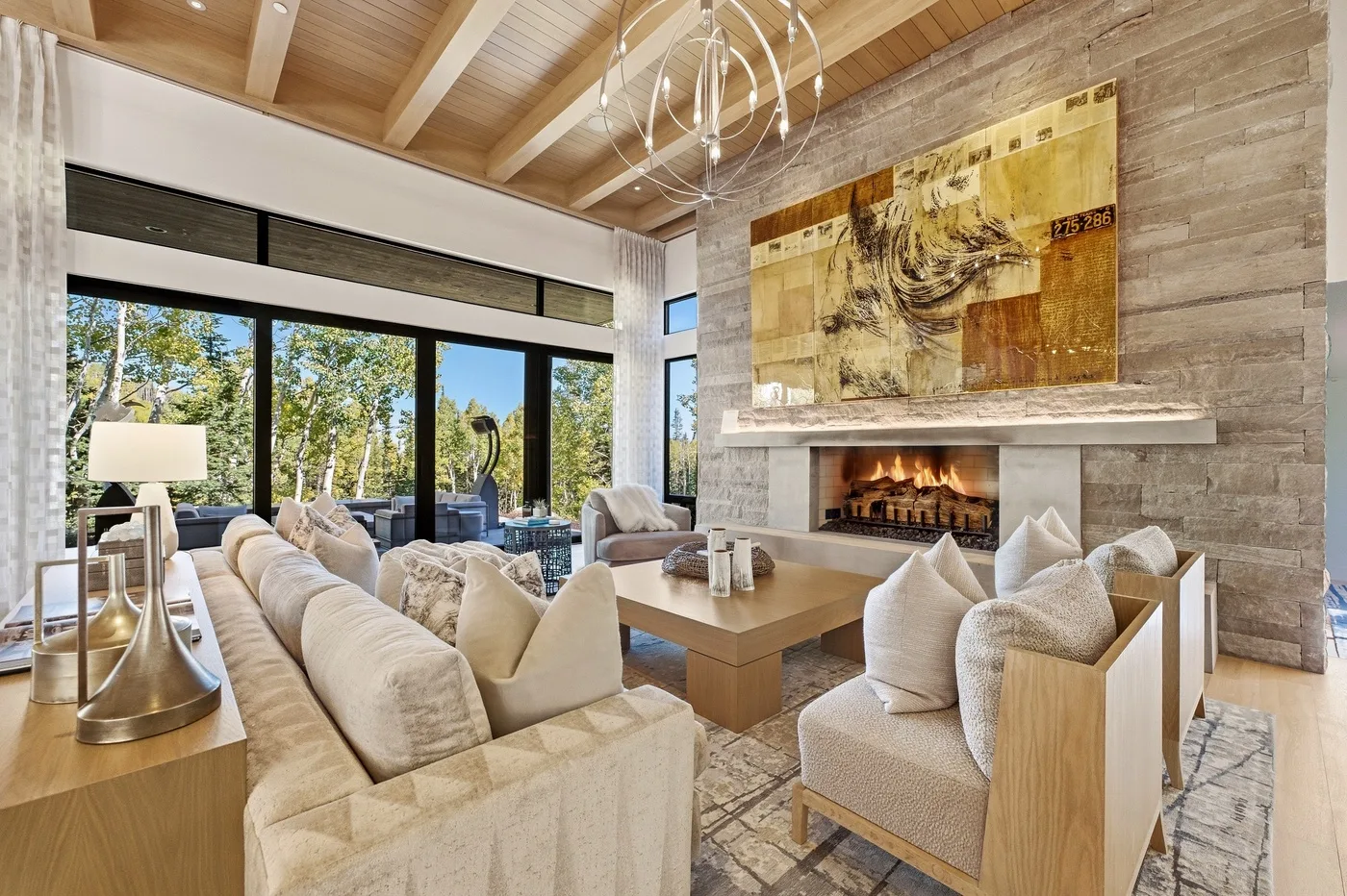A spacious living room with seating arranged around a fireplace and coffee table.