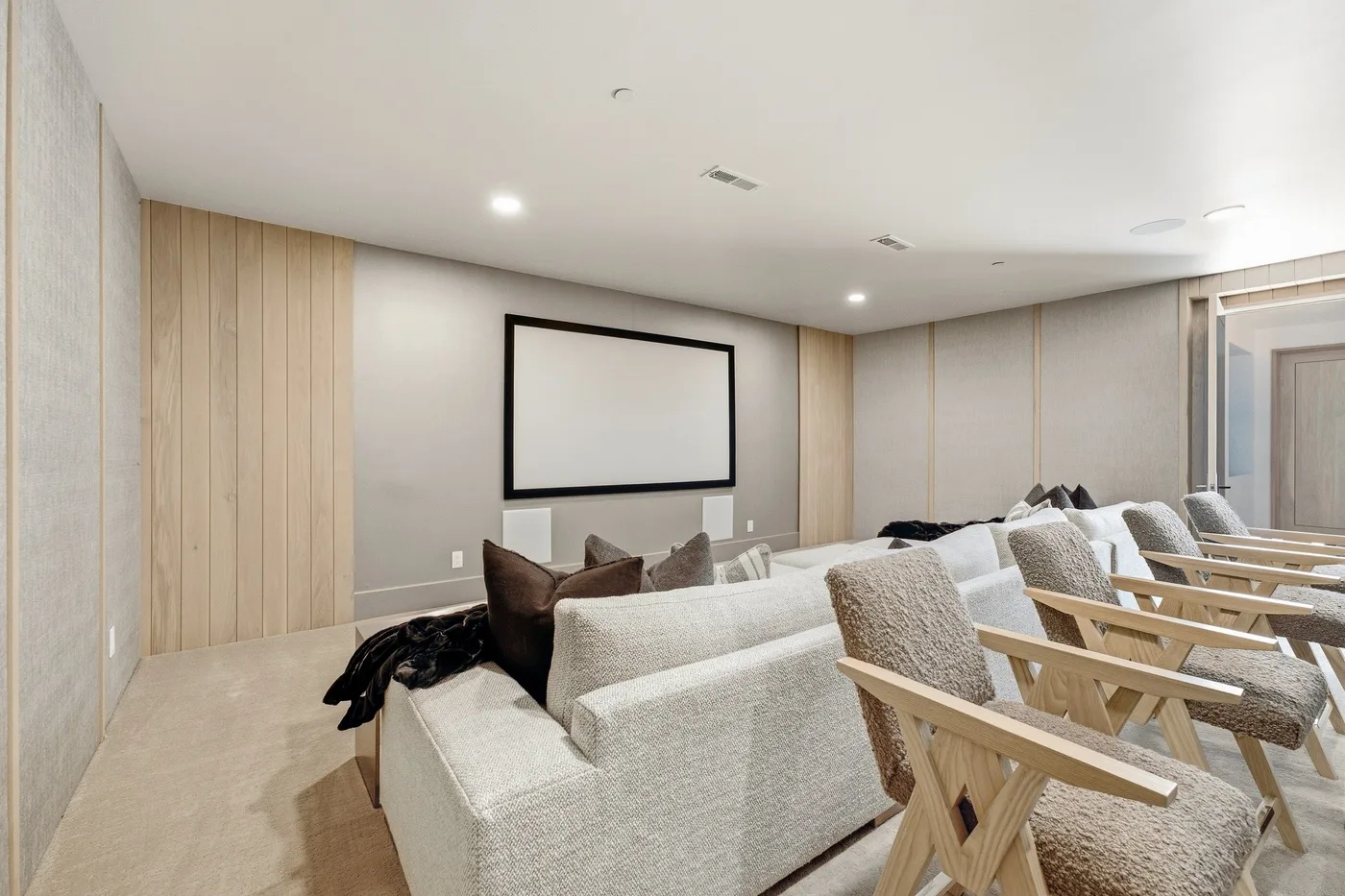 A lounge with rows of seating facing a blank projection screen.