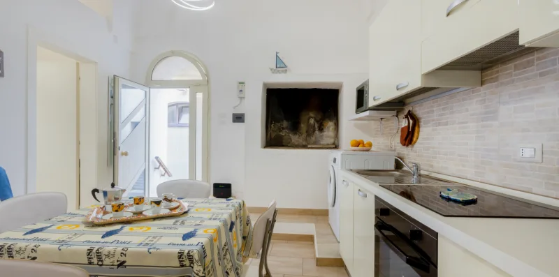 A kitchen and dining area with a table set beside the countertop.