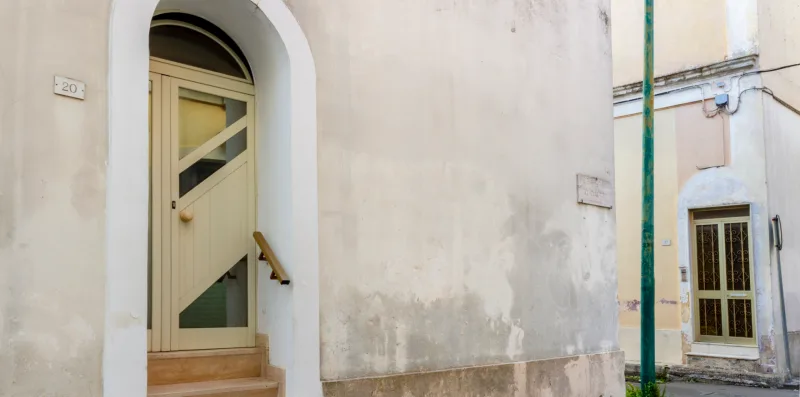 Una entrada exterior con una puerta arqueada y escalones.