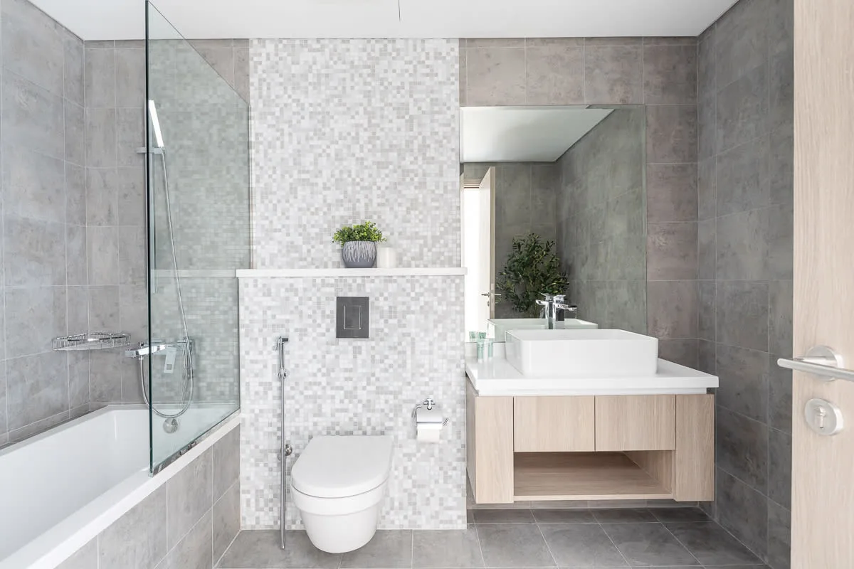 Un baño moderno con ducha de vidrio, inodoro y tocador.