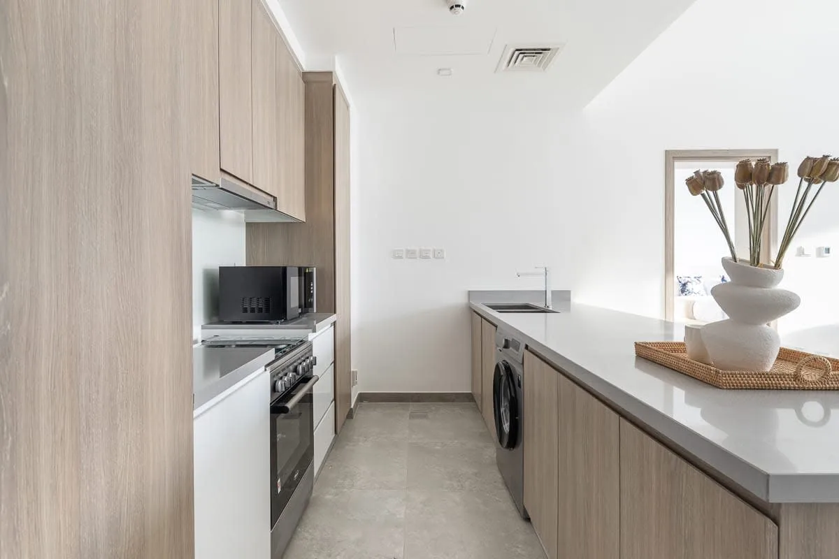 Una cocina moderna con electrodomésticos integrados y una larga encimera central.
