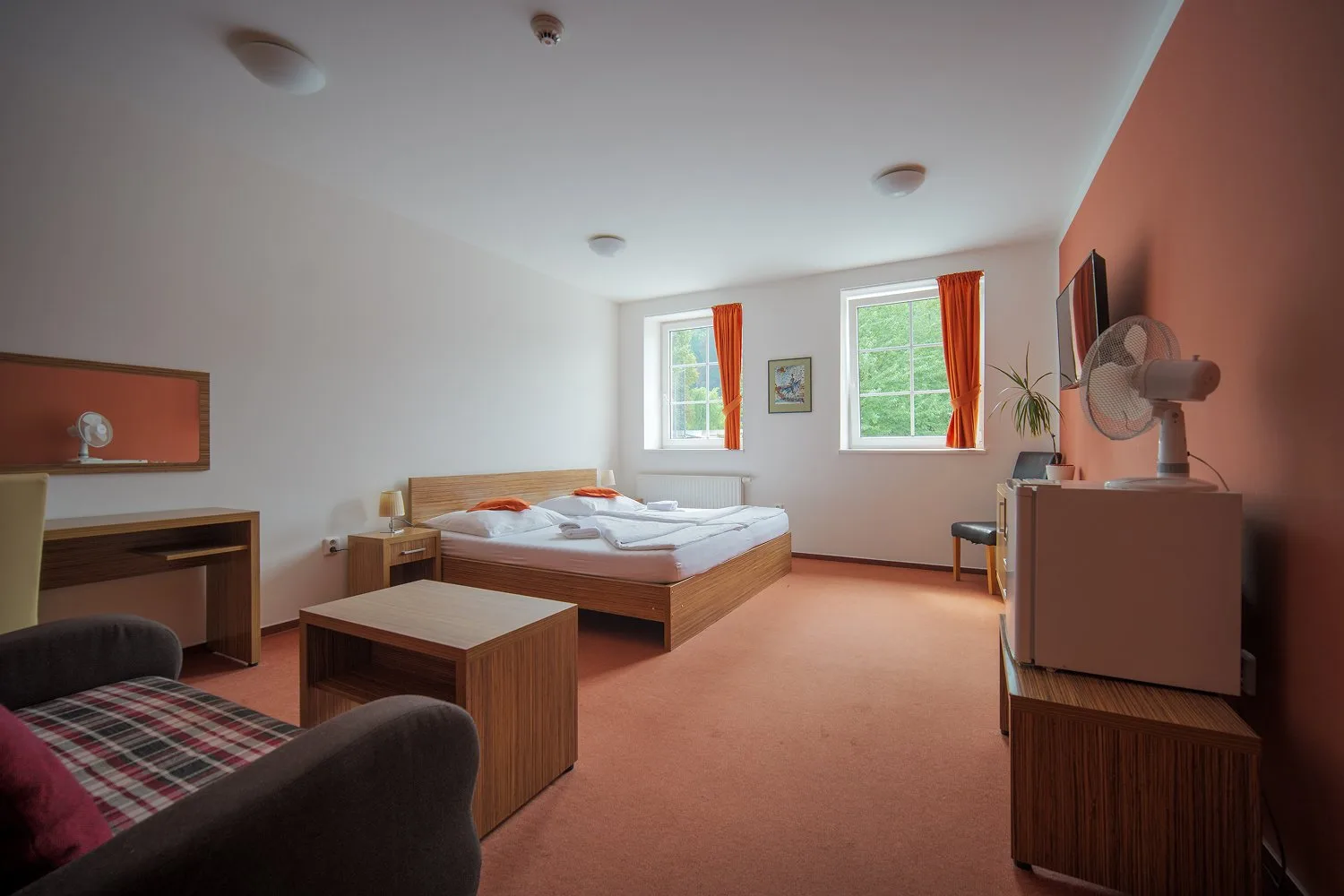 Habitación de hotel amplia con cama doble y zona de estar