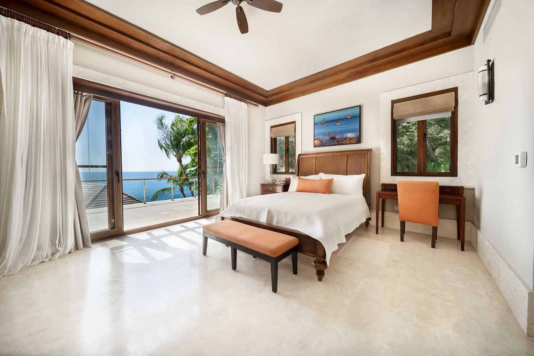 A bright bedroom with a bed and sliding glass doors opening onto a balcony.