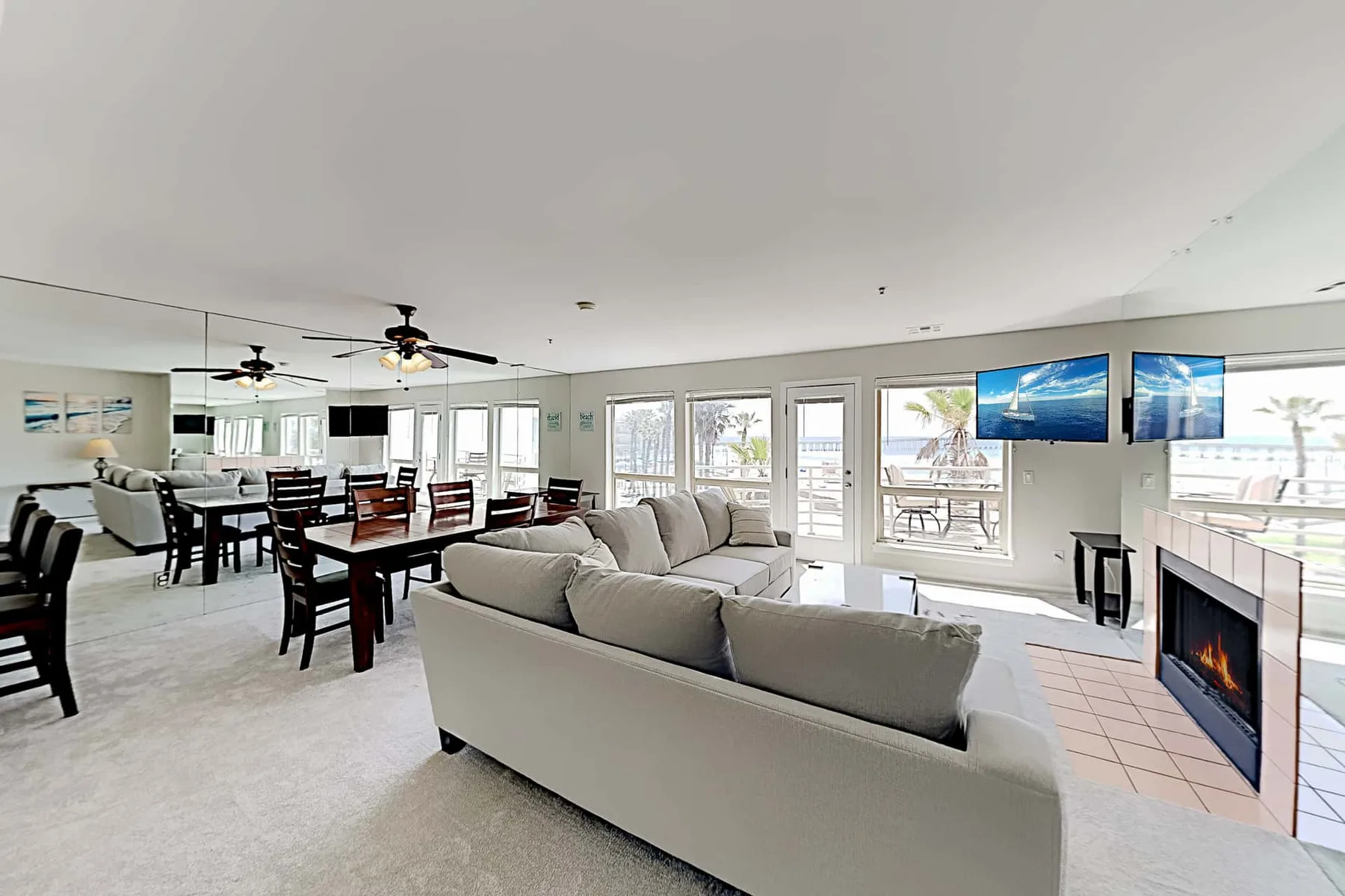 An open living and dining area features seating, a dining table, and a fireplace.