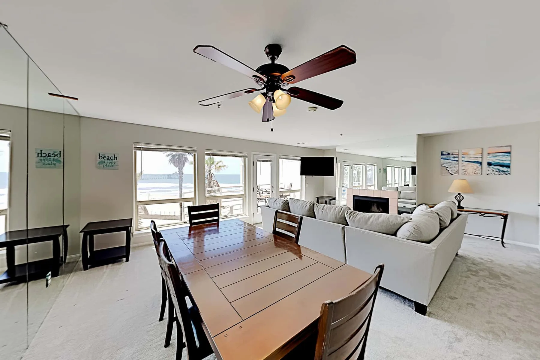 A bright open-plan living and dining area with a long wooden table and seating.