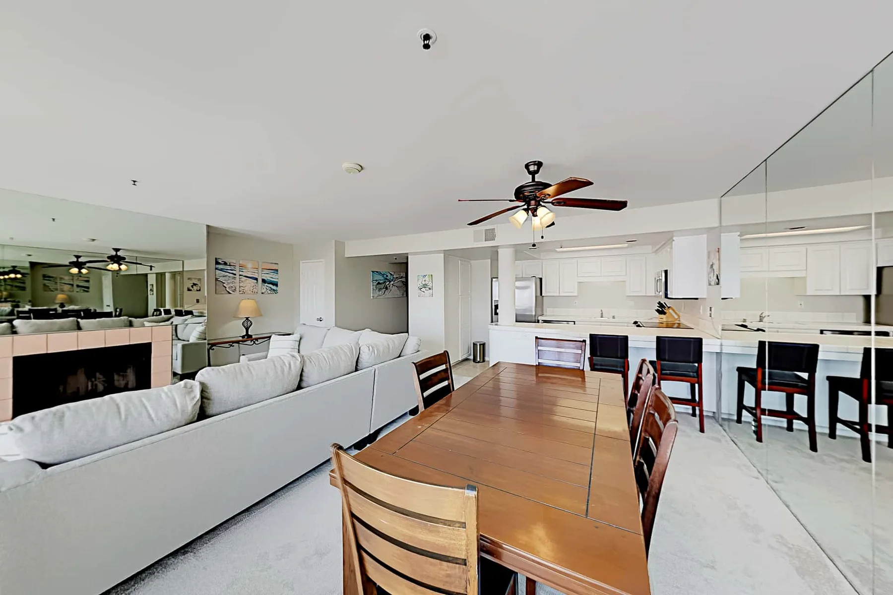 An open-plan living and dining area with a long wooden table and kitchen.