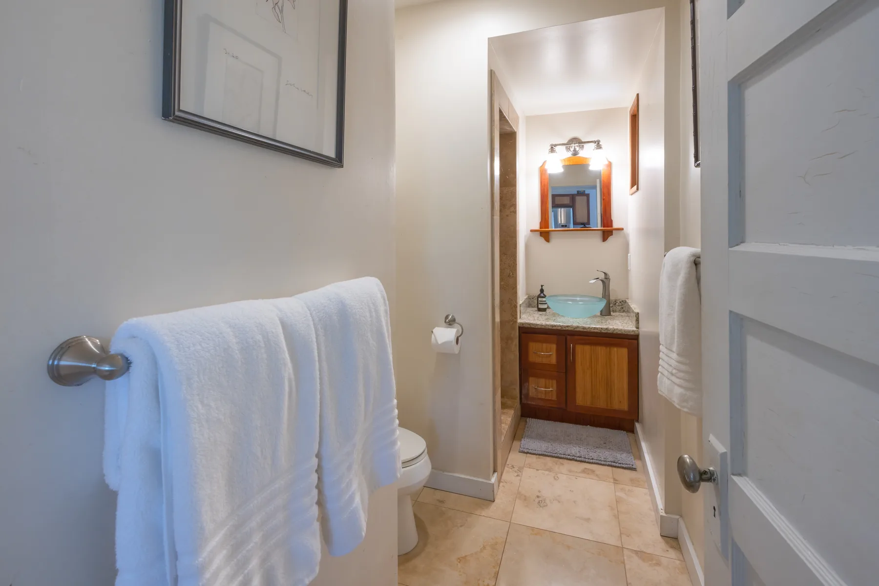 A bathroom with a sink, mirror, and towels.