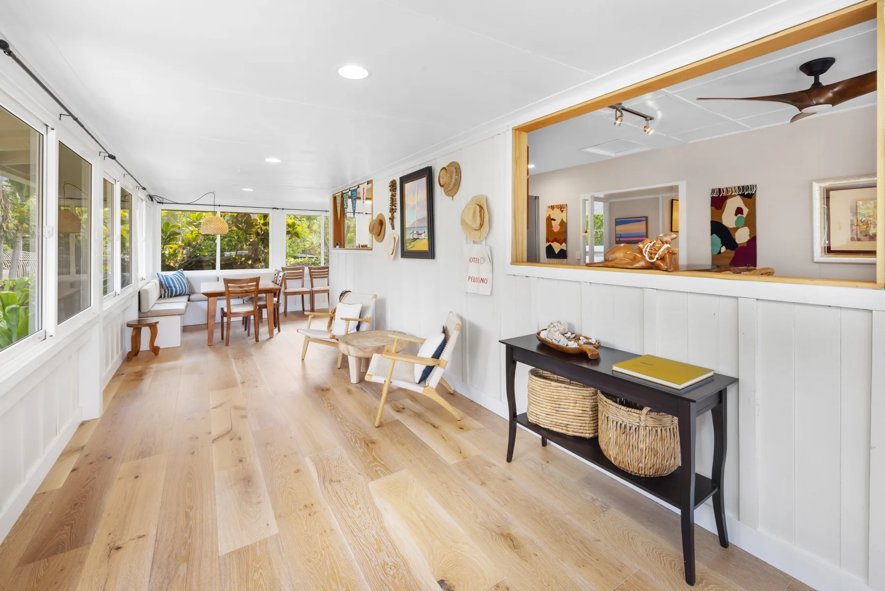 Un solárium luminoso con una mesa de comedor y asientos junto a grandes ventanas.