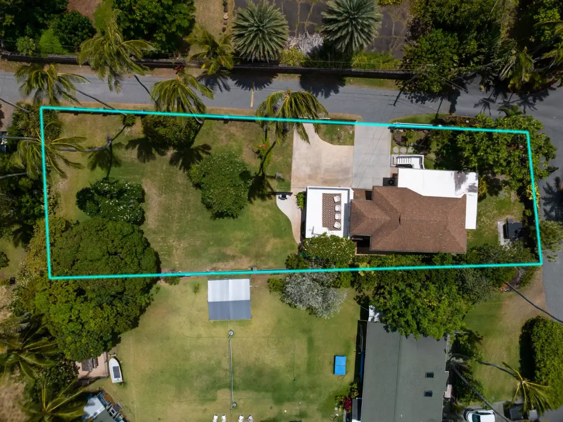 An aerial view shows a house and landscaped grounds.