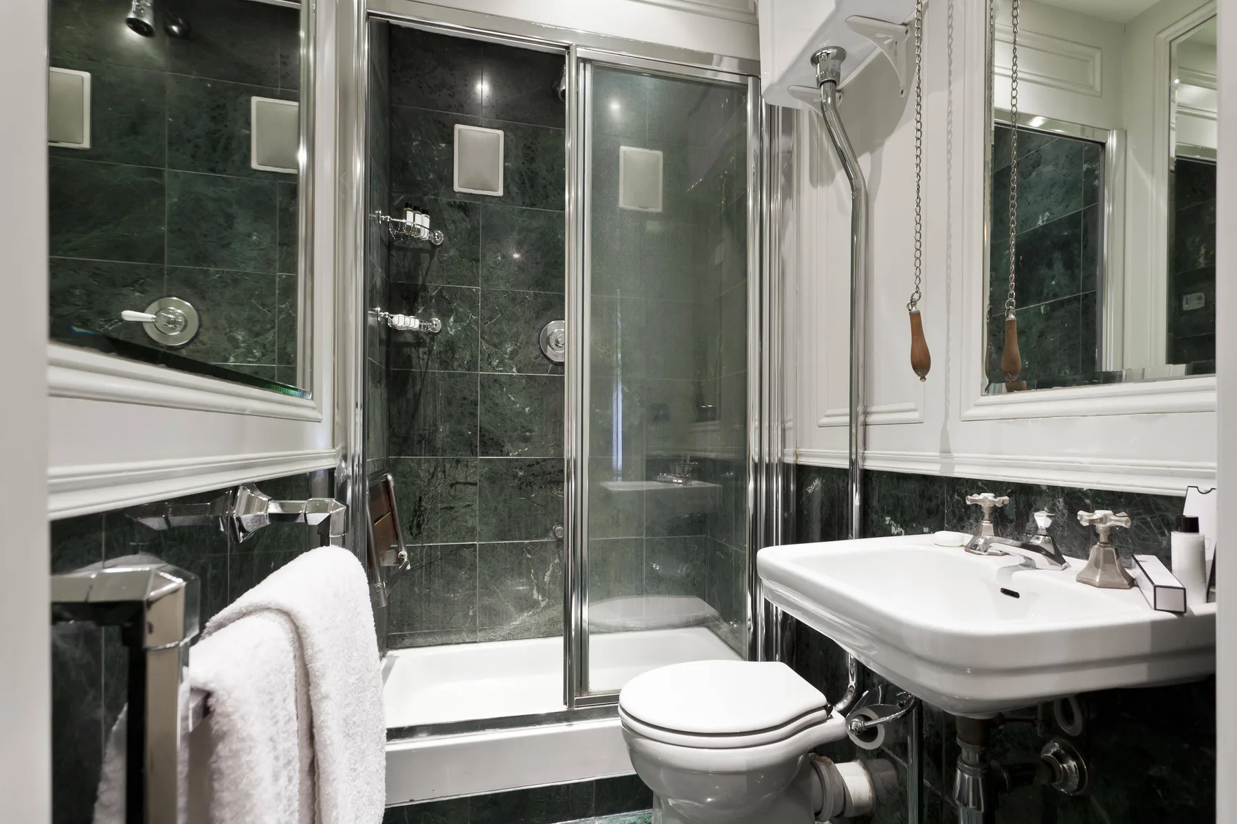 Un baño con ducha de cristal, inodoro y lavabo blanco.