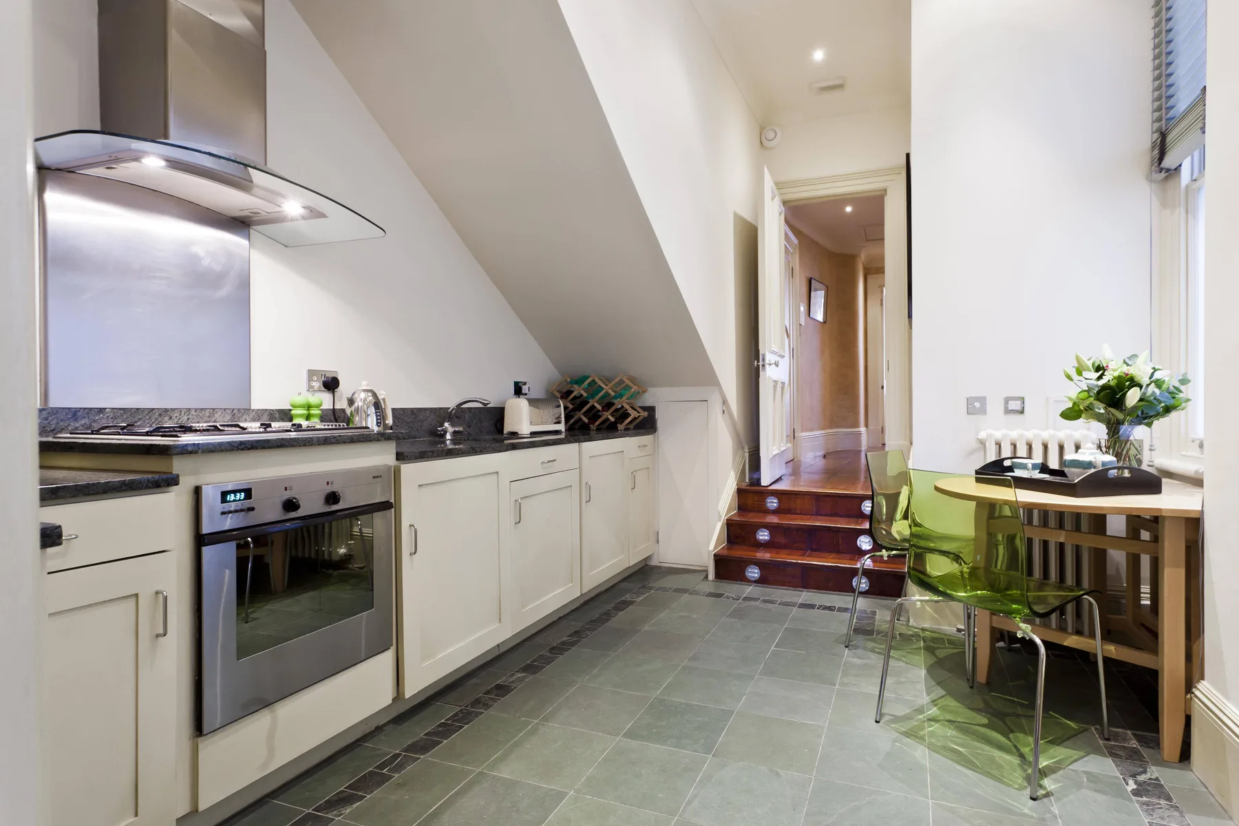 Una cocina compacta con una mesa de comedor junto a una ventana.