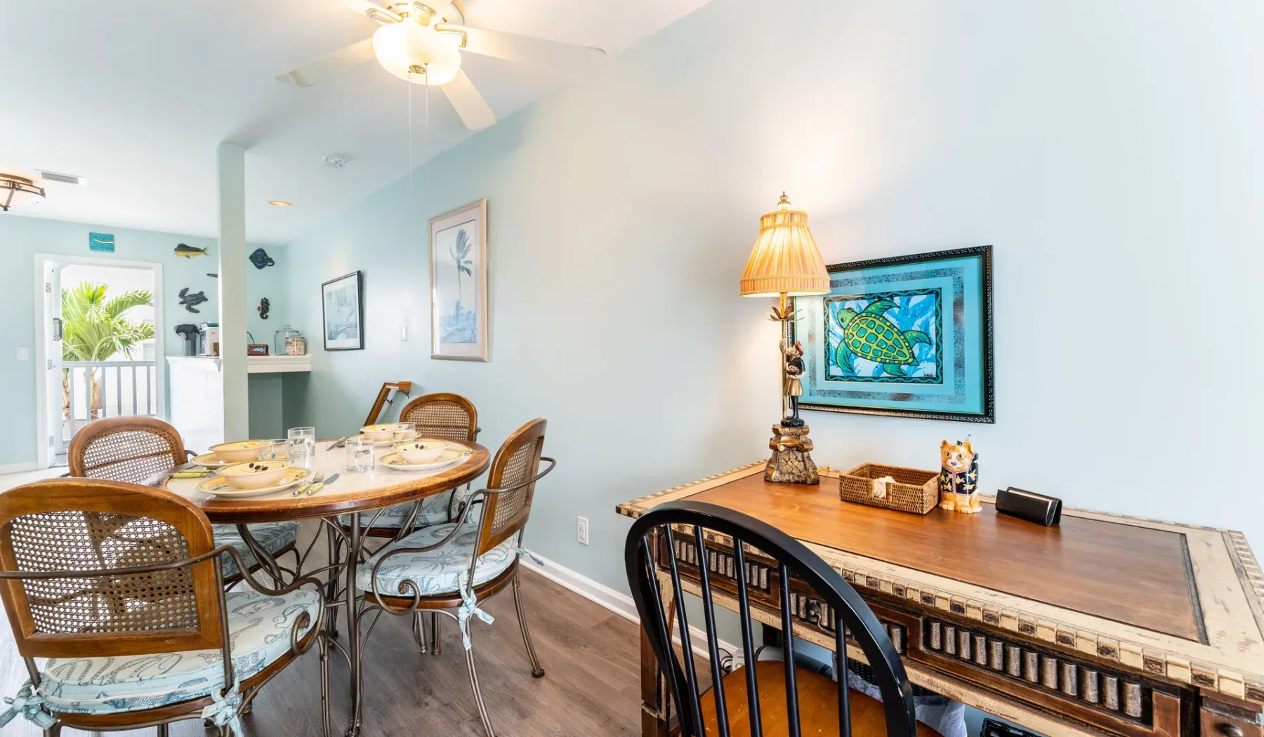Un comedor con una mesa de madera, sillas y cuadros en la pared.