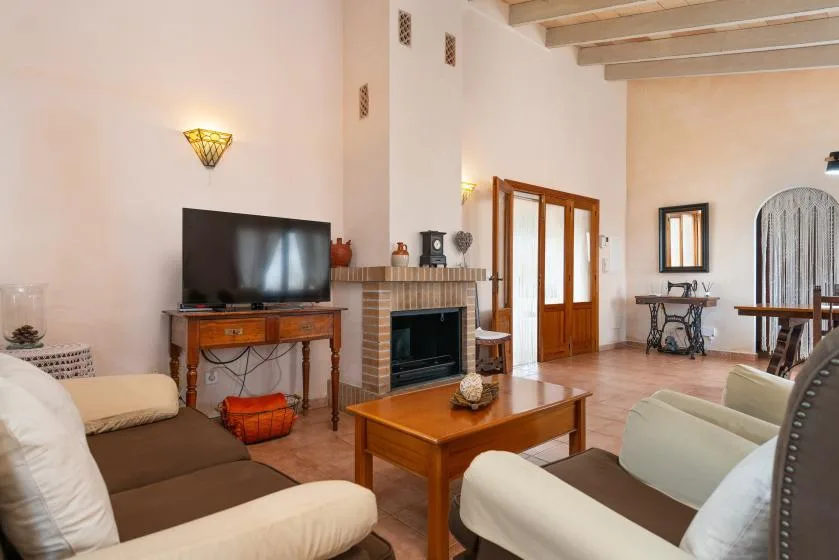 Una amplia sala de estar con asientos, un televisor y una chimenea.