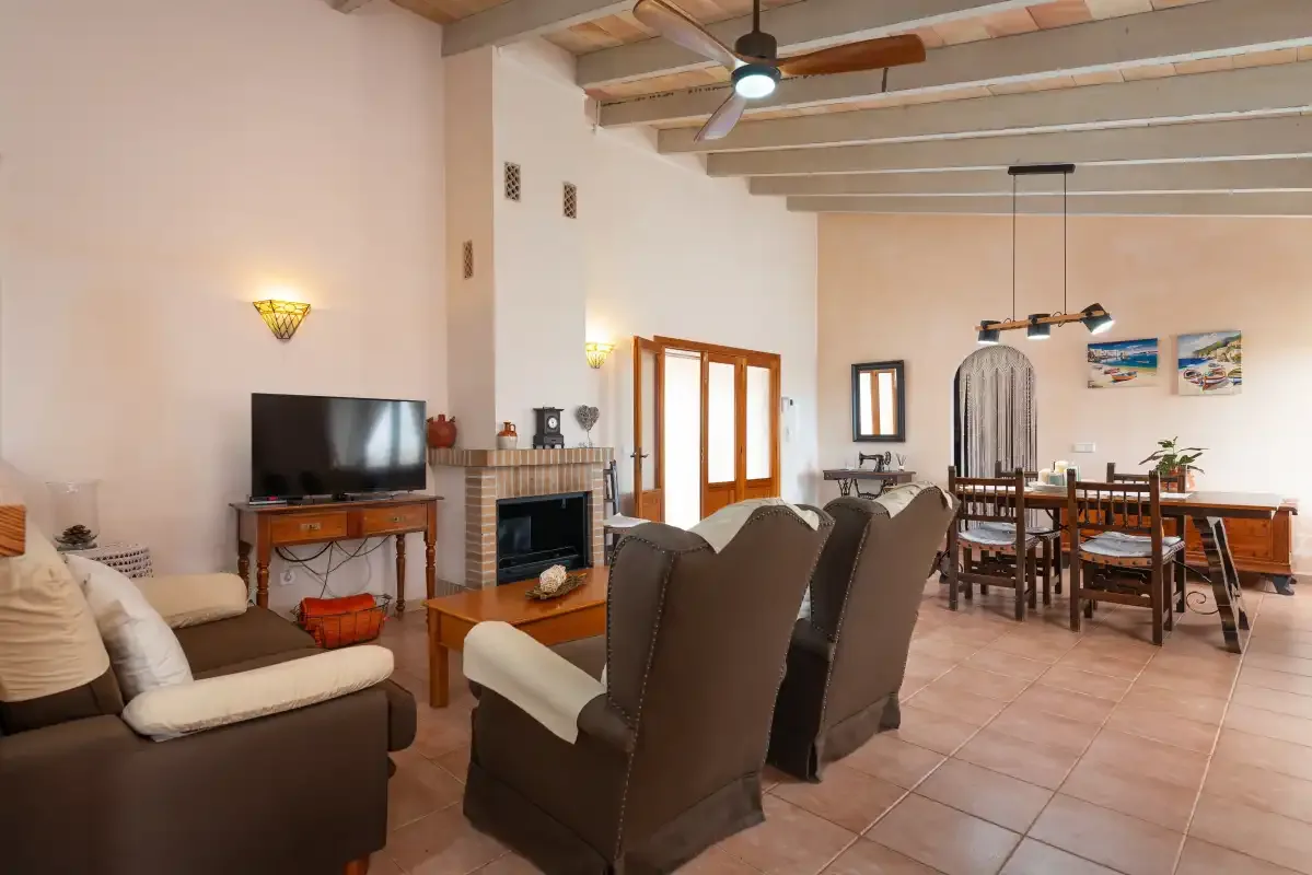 Sala de estar y comedor con asientos, un televisor y una mesa de comedor.