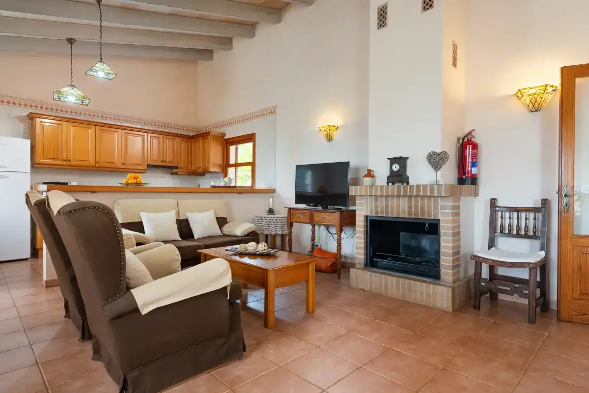 Una sala de estar con asientos, una mesa de centro de madera y una chimenea.