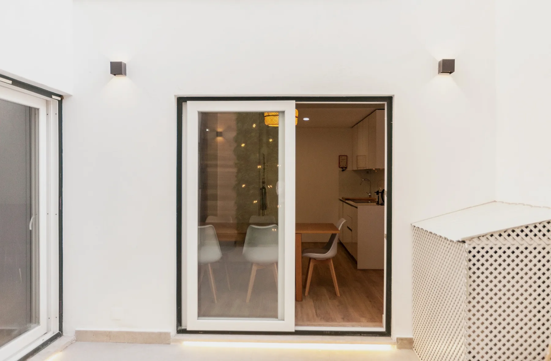 A terrace opens through sliding glass doors to a dining area and kitchen.