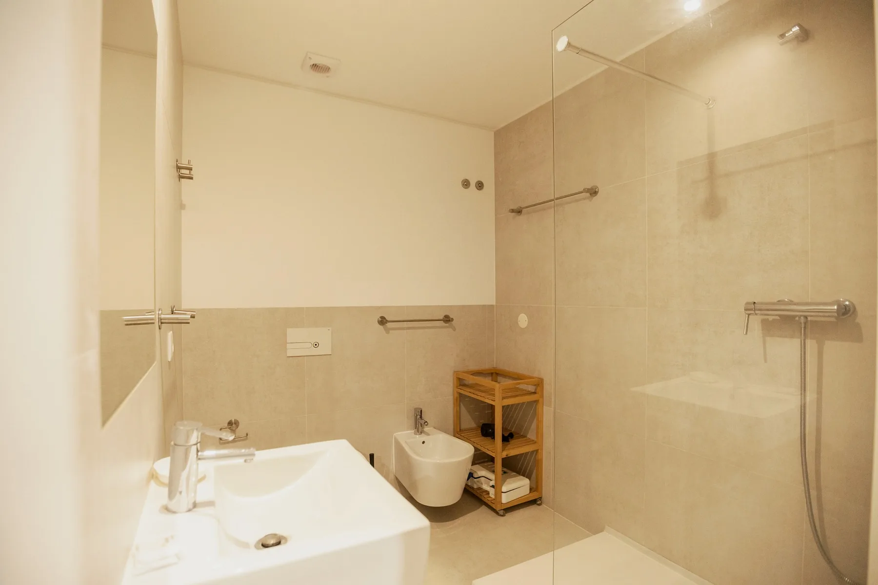 A bathroom with a sink, toilet, and glass shower screen.