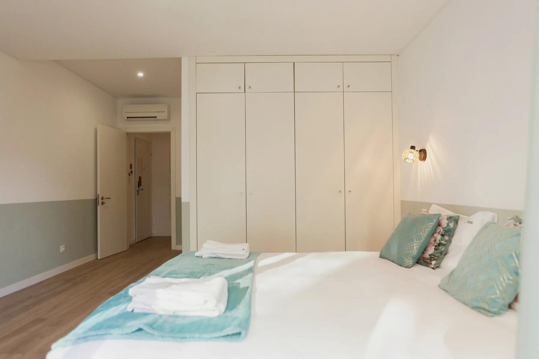 A bedroom with a neatly made bed and built-in wardrobes.