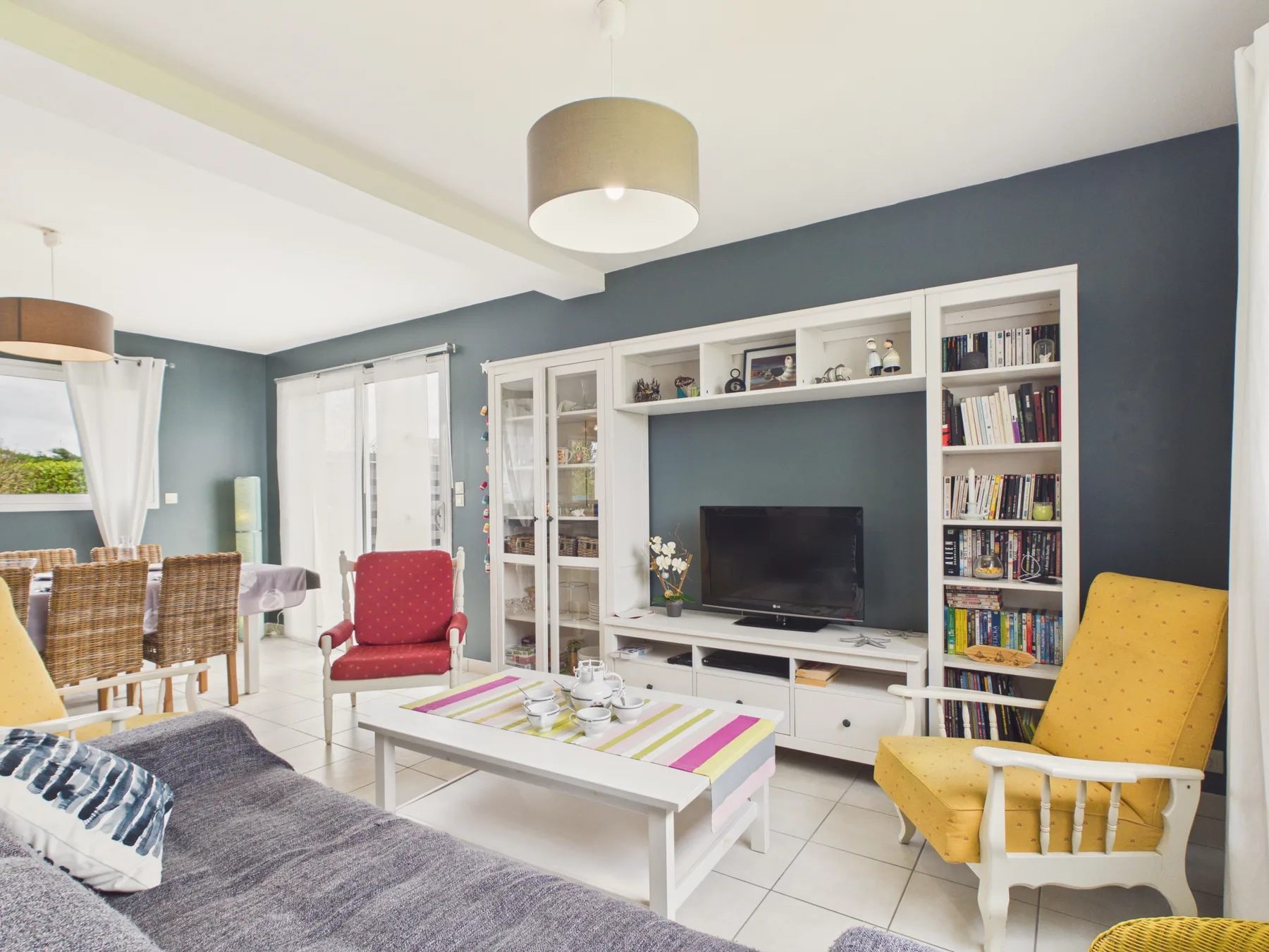 A living room with a television, shelving, and seating.