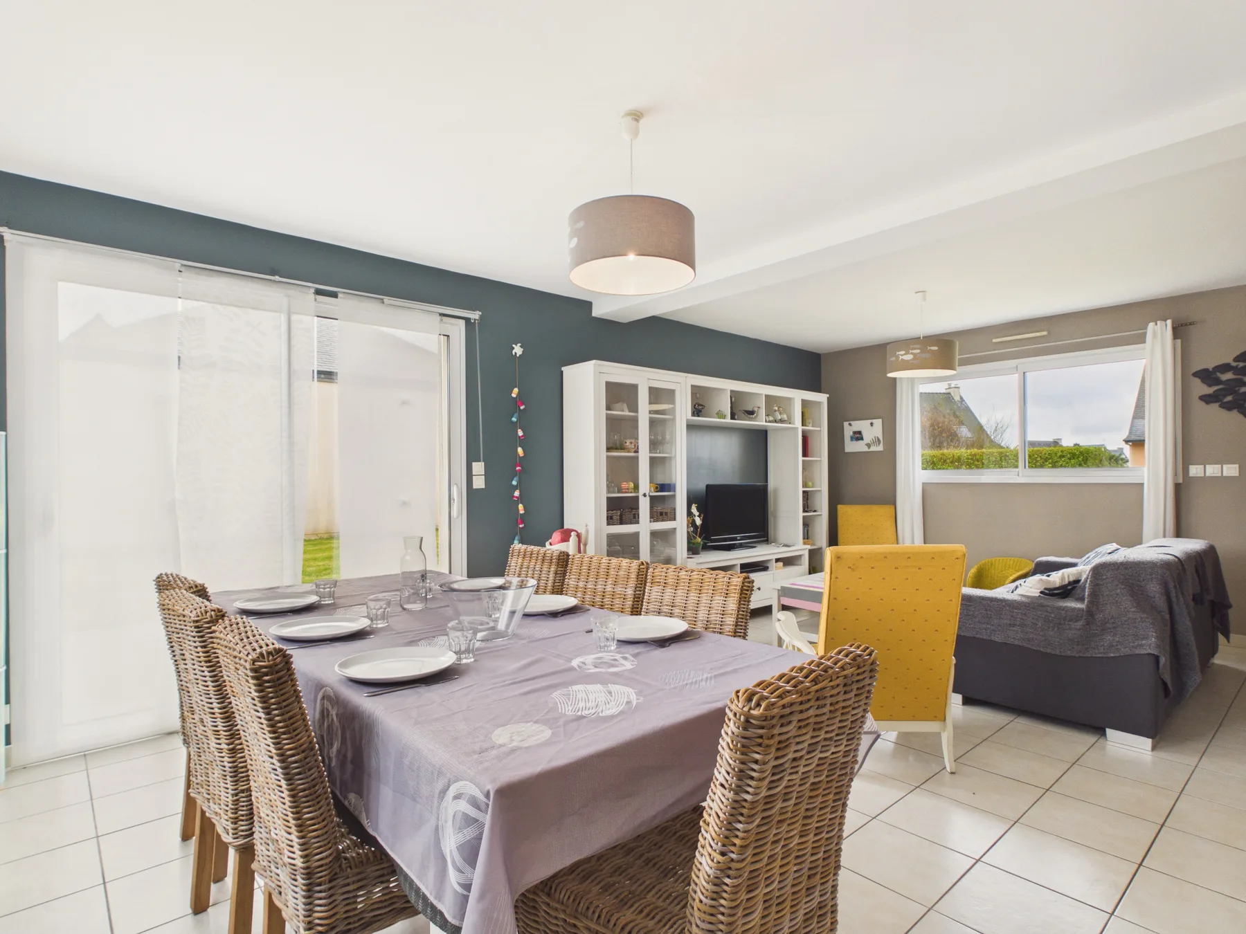 A dining area with a set table beside a living area.