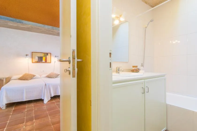 Se ve un dormitorio con dos camas junto a un lavabo de baño y una bañera.