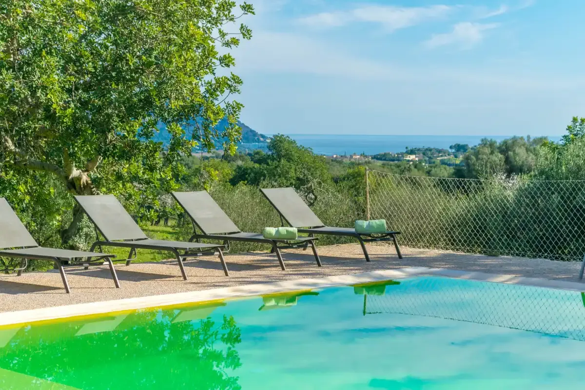 Una piscina al aire libre con asientos y vistas al mar.