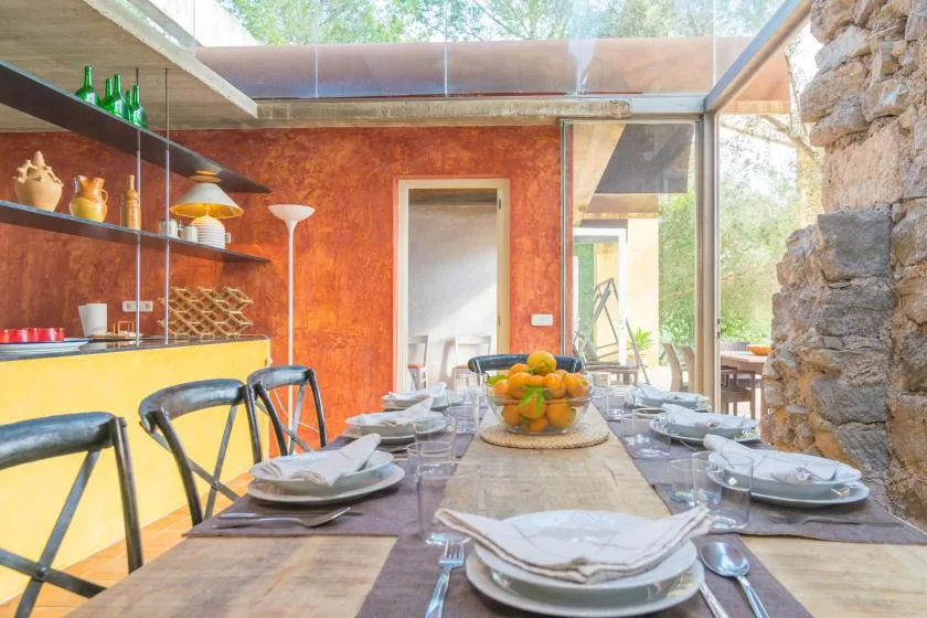 Comedor con una mesa larga puesta junto a una gran ventana.