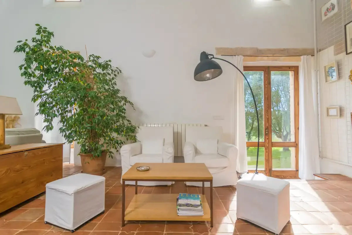 Una sala luminosa con asientos, una mesa de centro y una puerta acristalada.