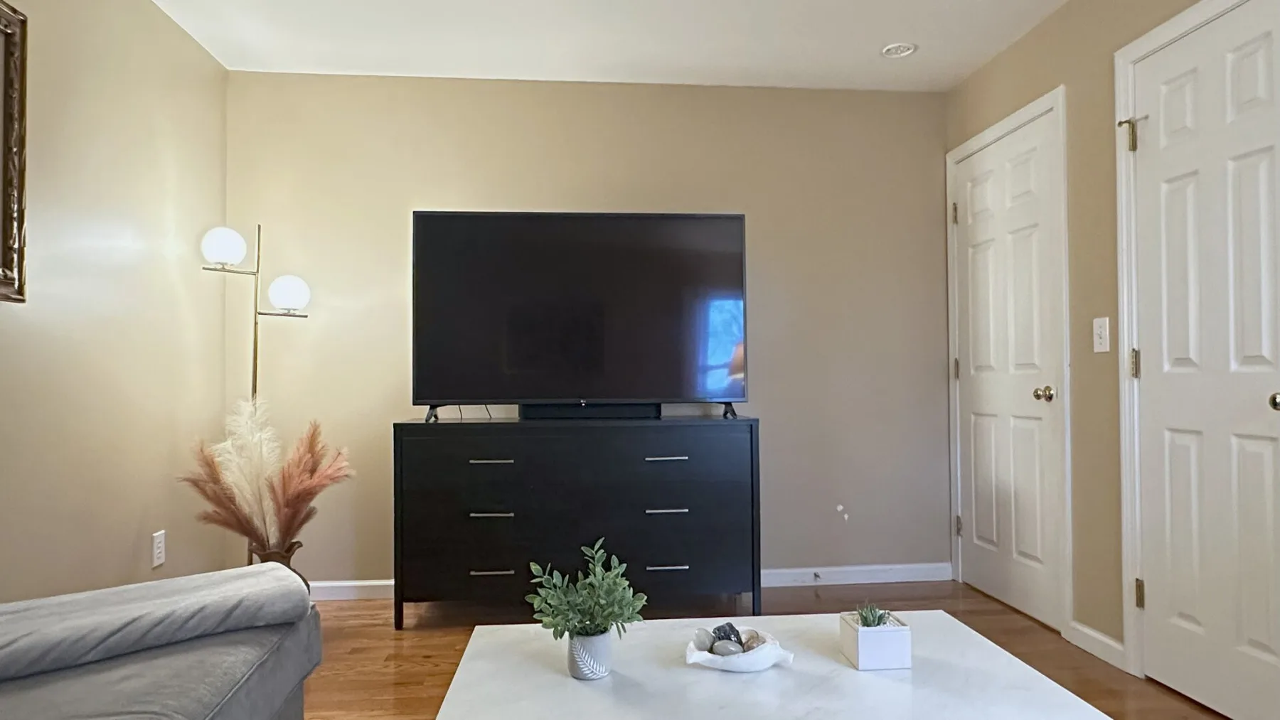 A living room with a television on a dark cabinet and a coffee table.