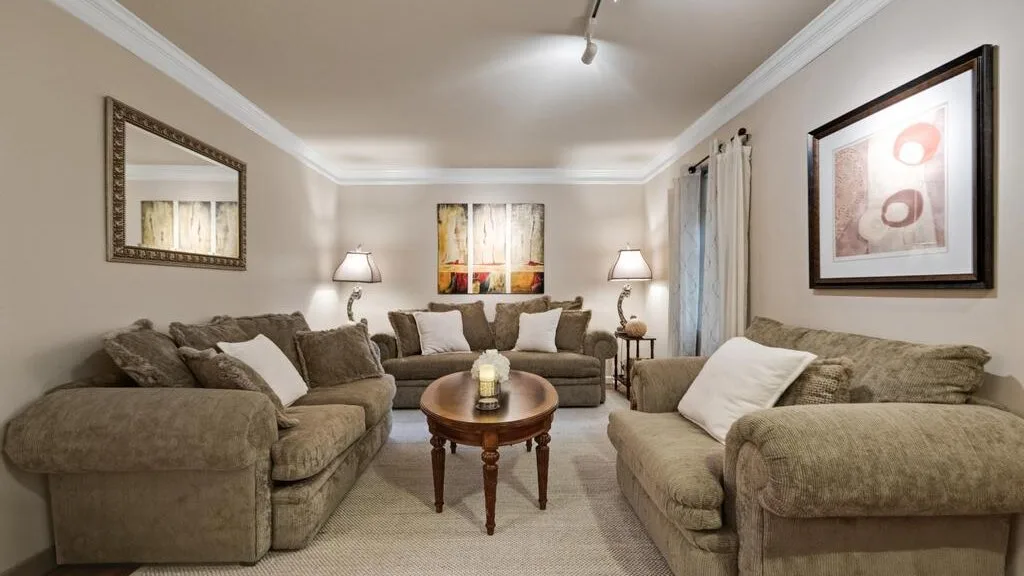 A living room with seating arranged around a wooden coffee table.