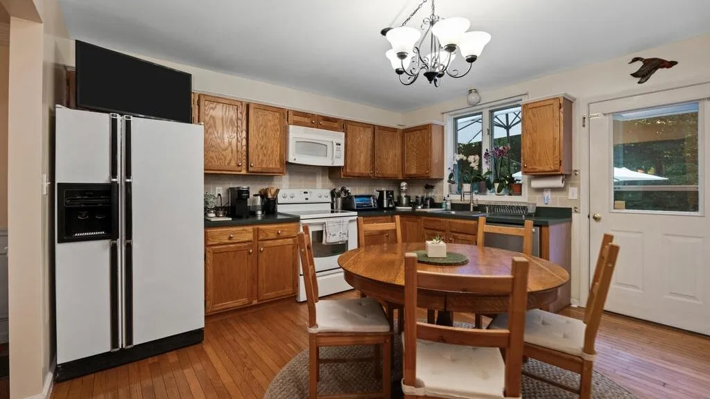 A kitchen and dining area with wooden cabinets and a round dining table.