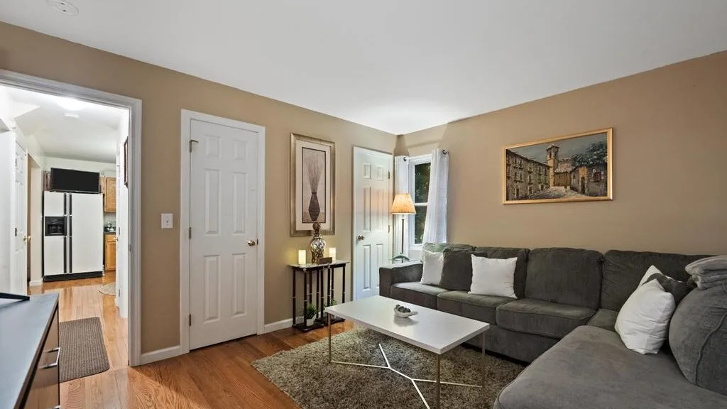 A living room with a sectional seating area, coffee table, and framed wall art.