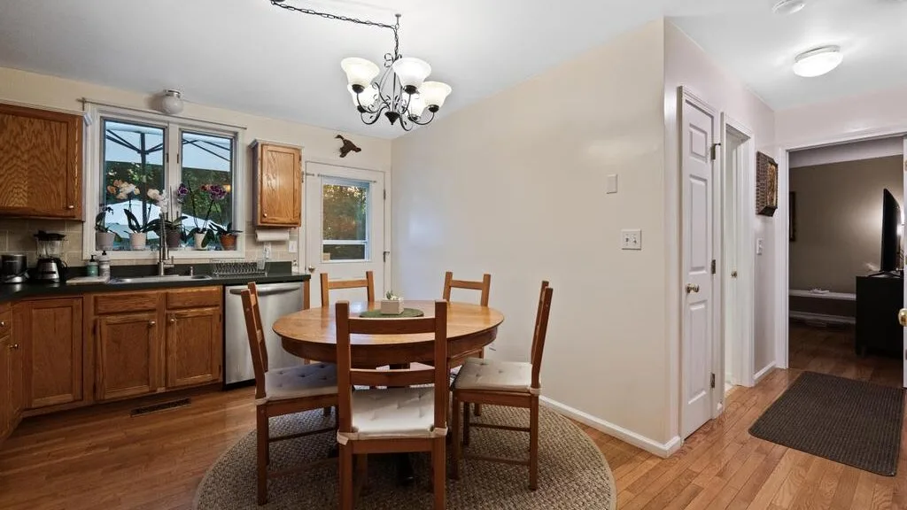 A kitchen and dining area with wooden cabinets and a round table.