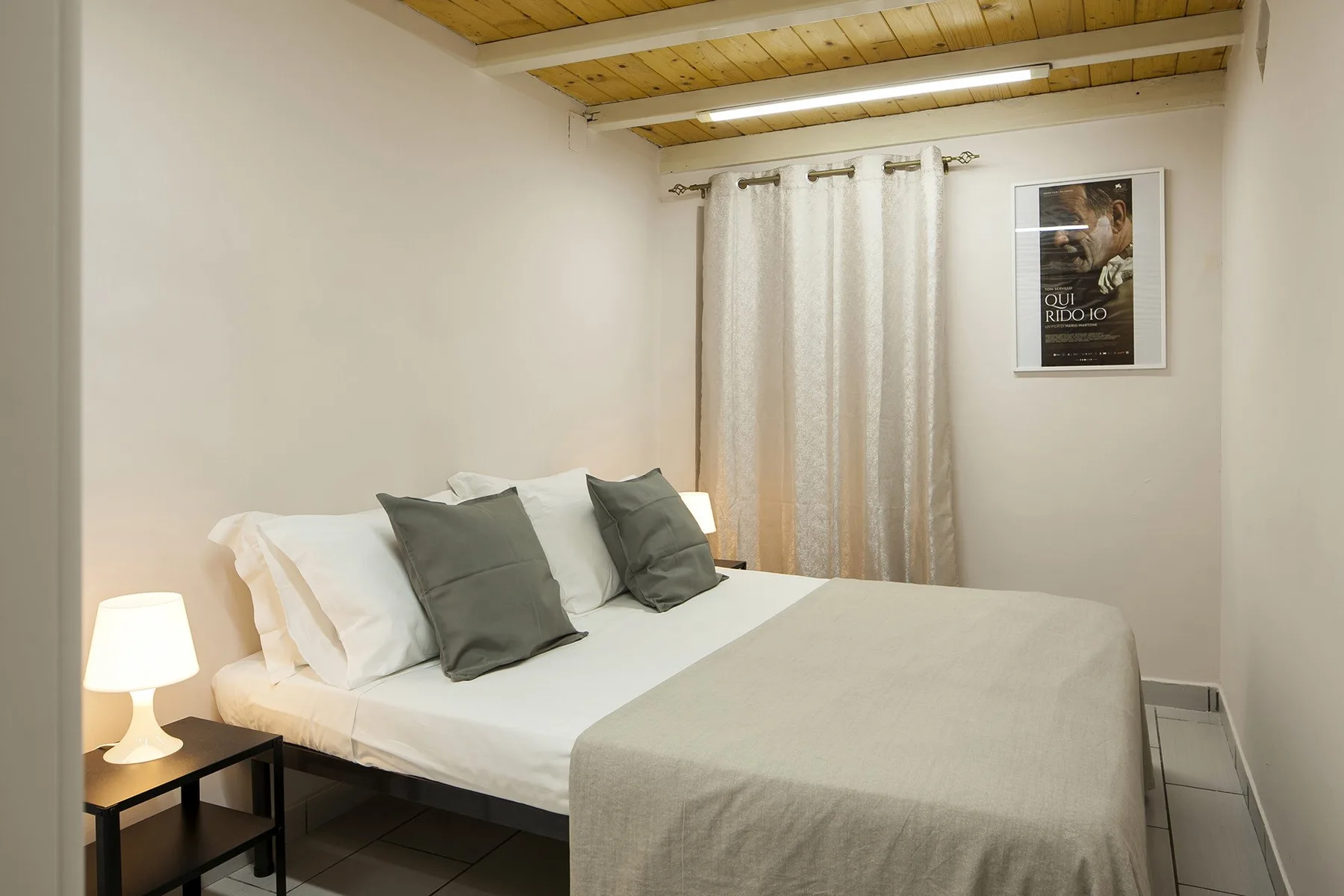 A bedroom with a neatly made bed and curtains covering the window.