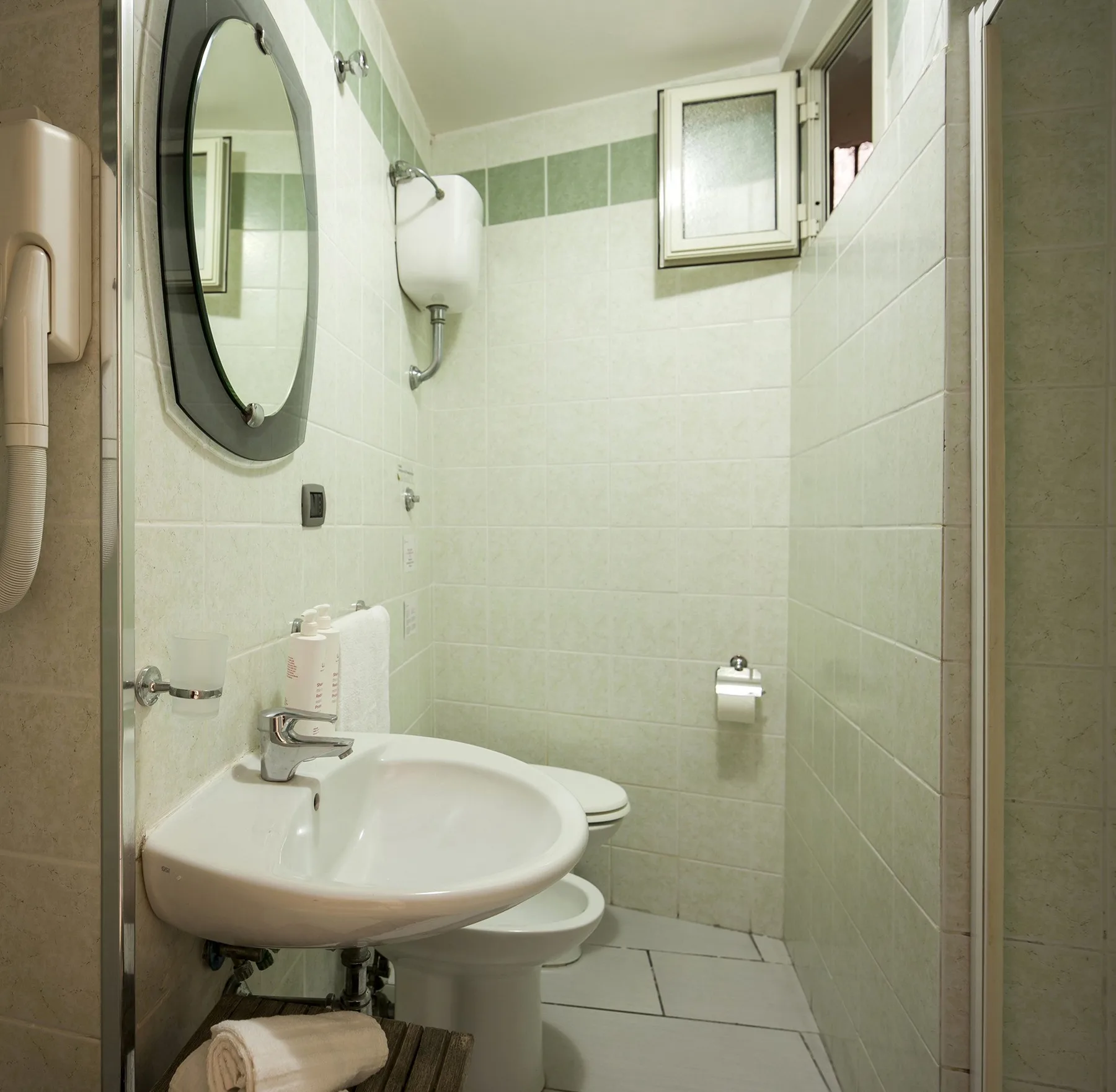 A tiled bathroom with a sink, toilet, and shower.