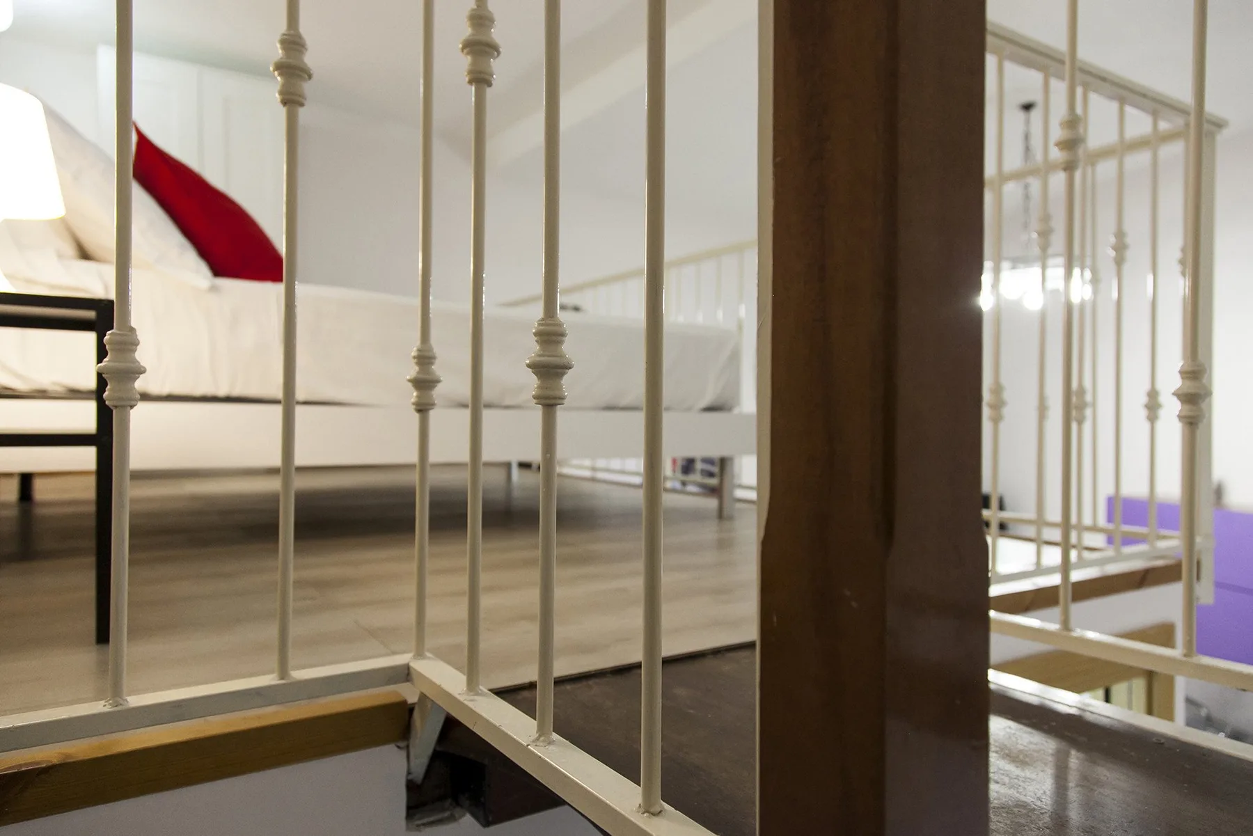 A bedroom with a raised bed and metal railings.