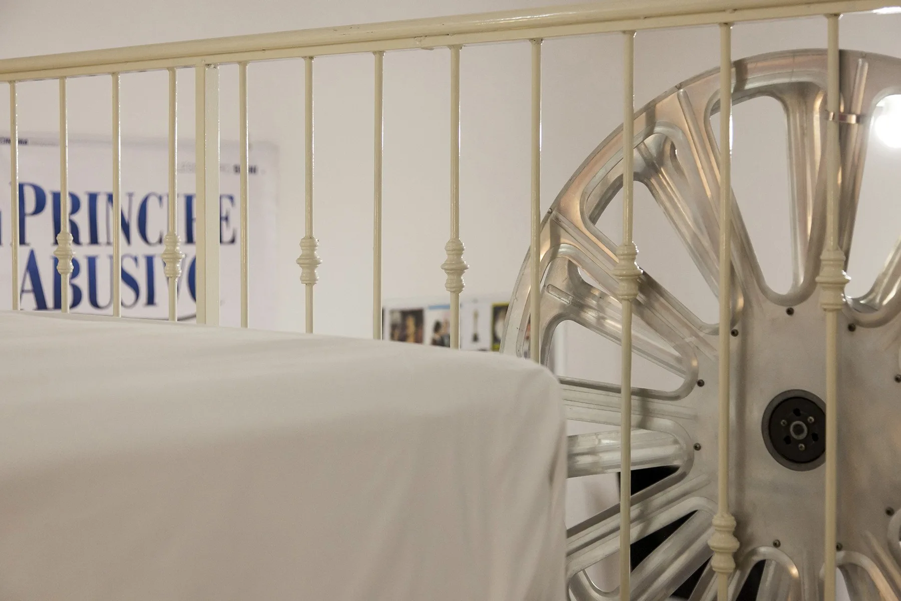 A bed in a bedroom, with an ornate metal headboard beside the wall.