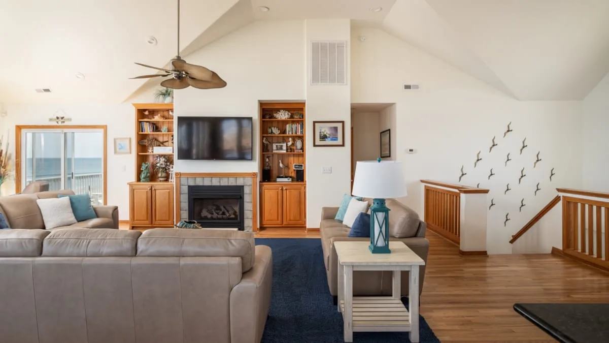 Una sala de estar con asientos, un televisor y una chimenea.