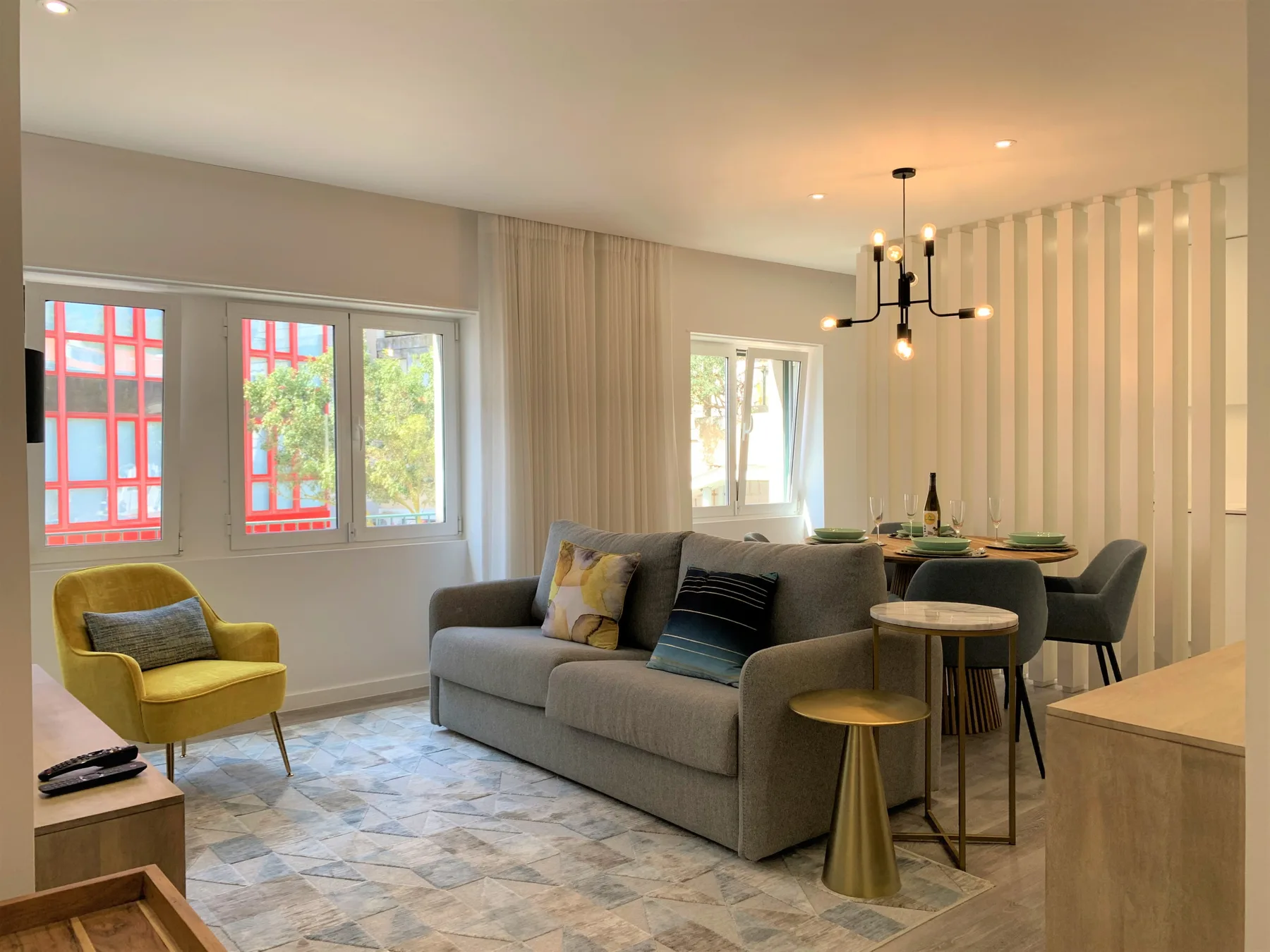 Una luminosa sala de estar y comedor con asientos, ventanas amplias y una mesa de comedor.
