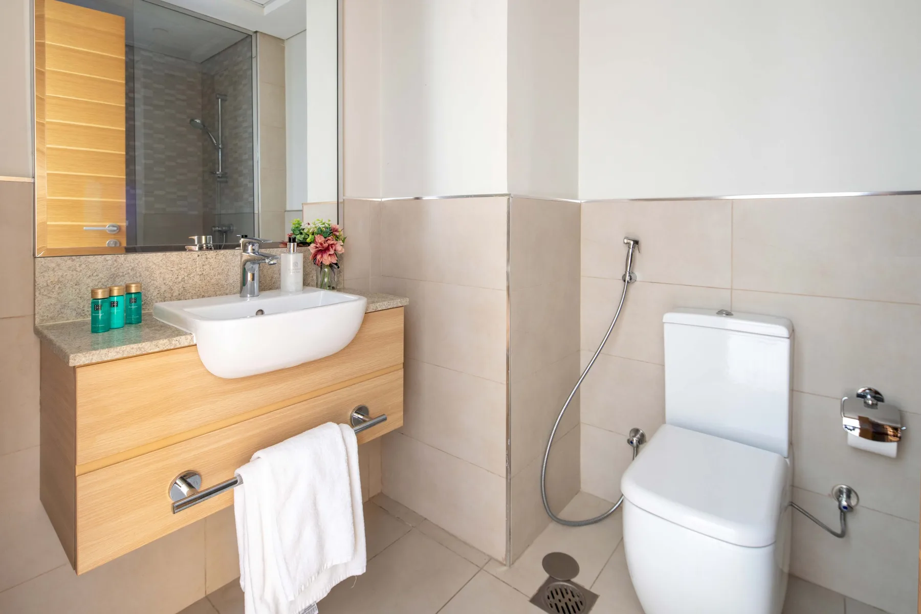 A bright bathroom with a wall-mounted sink and toilet.