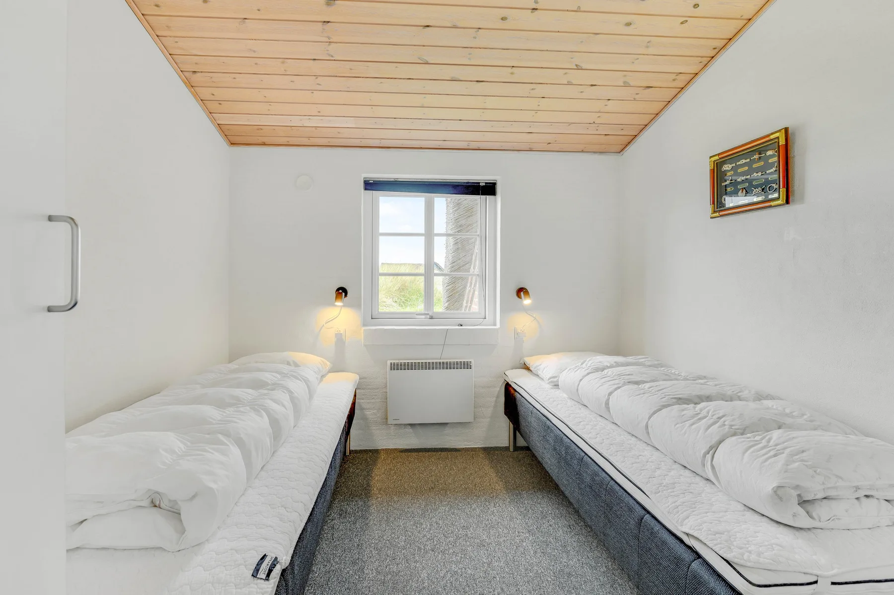 Un dormitorio con dos camas bajo un techo de madera inclinado.
