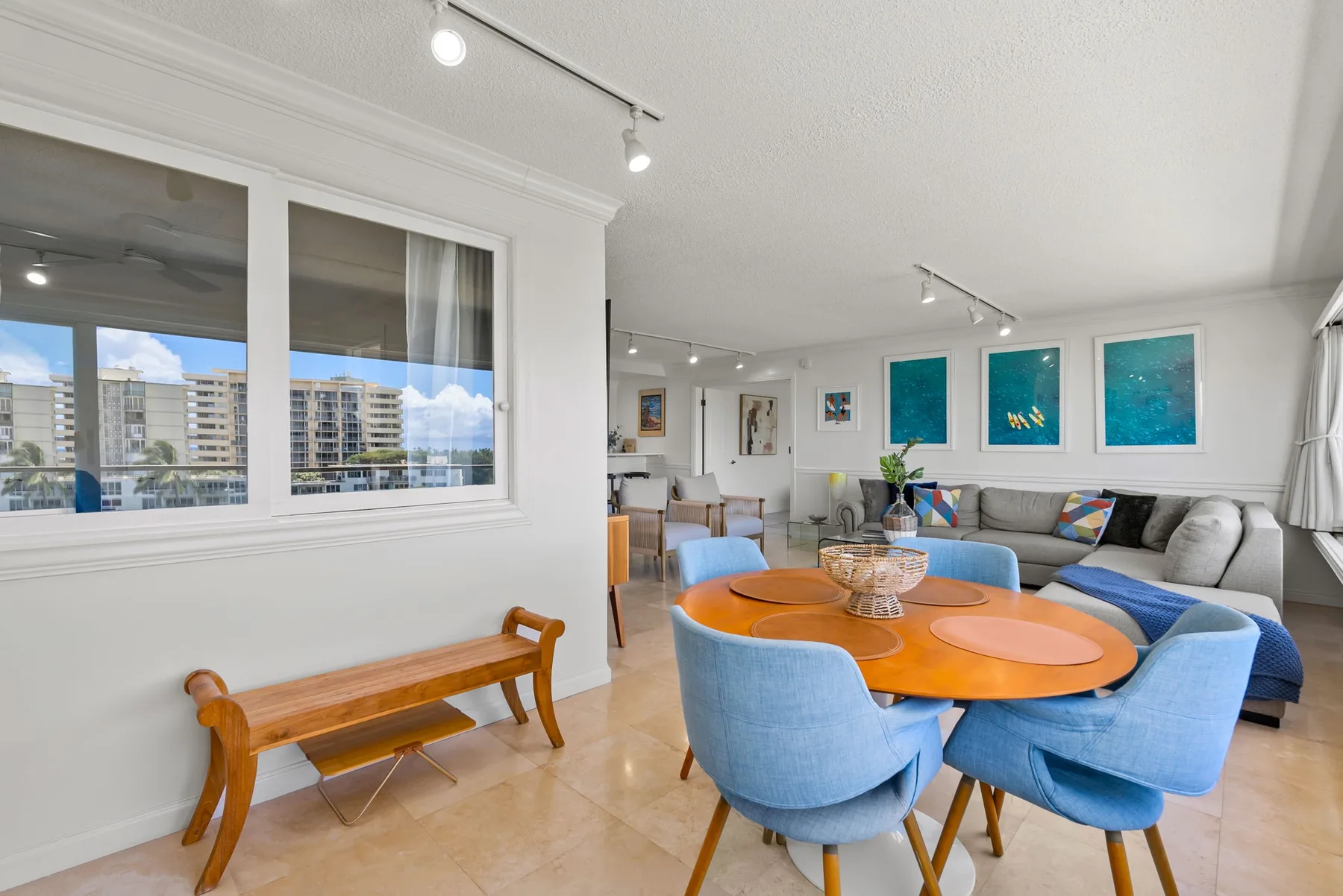 Una sala luminosa con una mesa redonda y asientos tapizados azules.