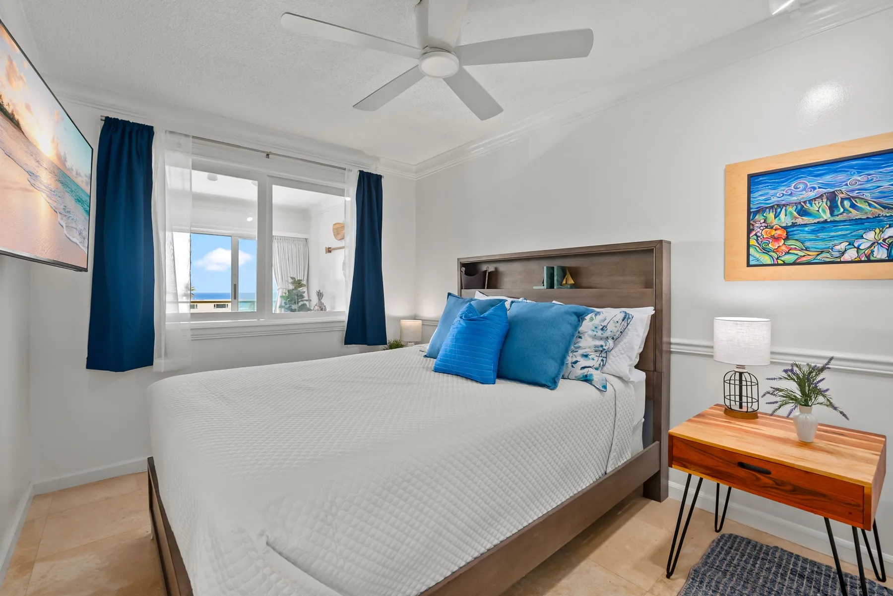 Un dormitorio luminoso con una cama bien arreglada bajo un ventilador de techo.