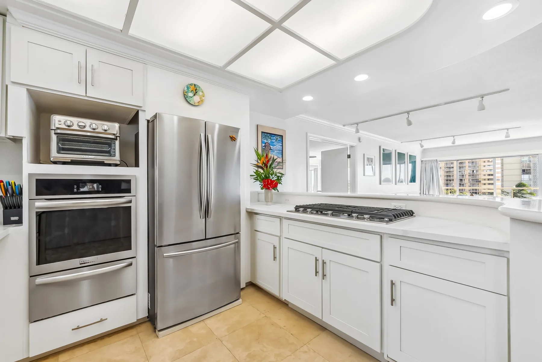 Una cocina luminosa con electrodomésticos de acero inoxidable y gabinetes blancos.