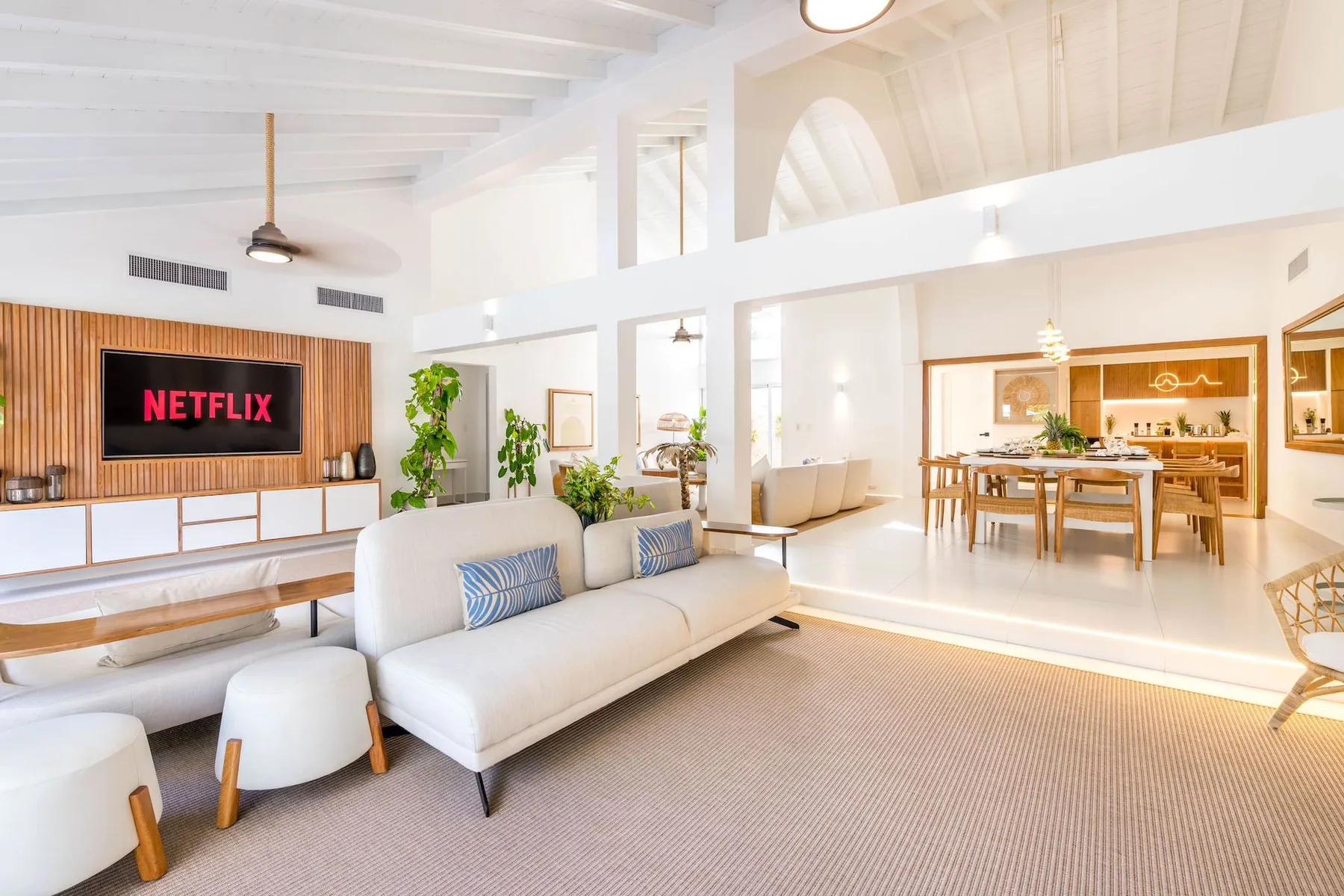 A bright open-plan living and dining area with a white sofa and dining table.