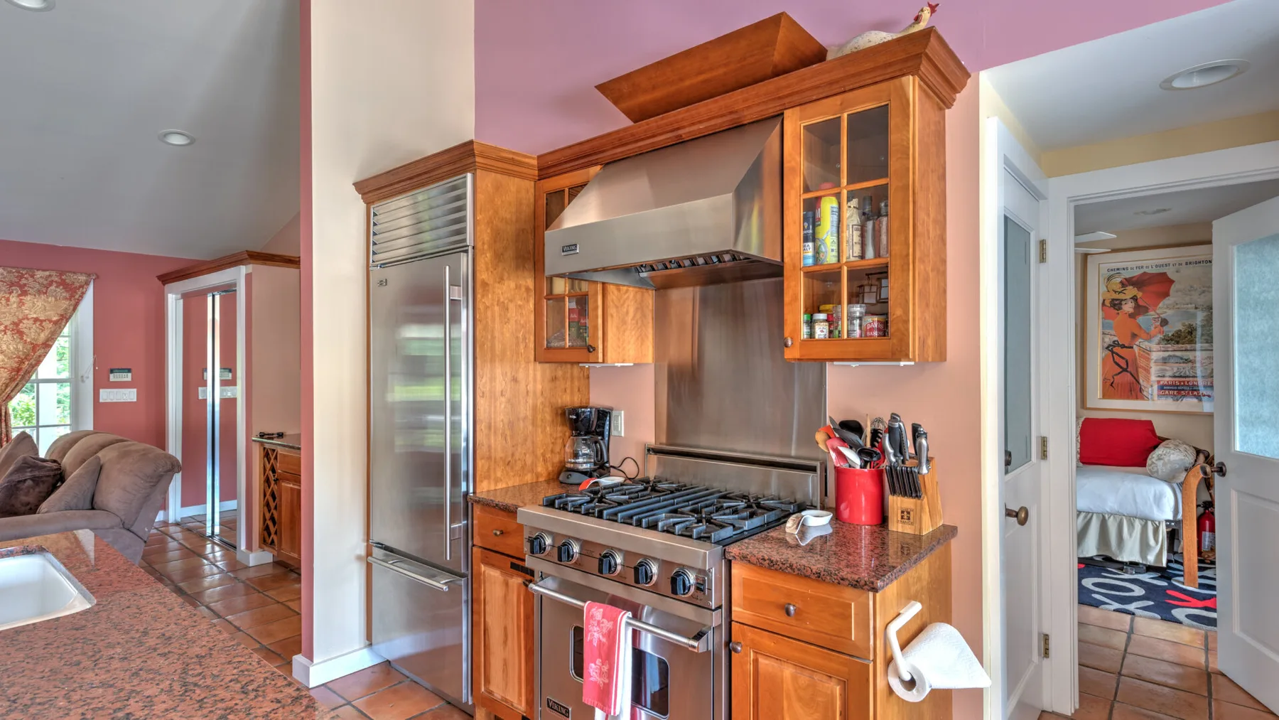 Una cocina con gabinetes de madera, un refrigerador grande y una estufa.